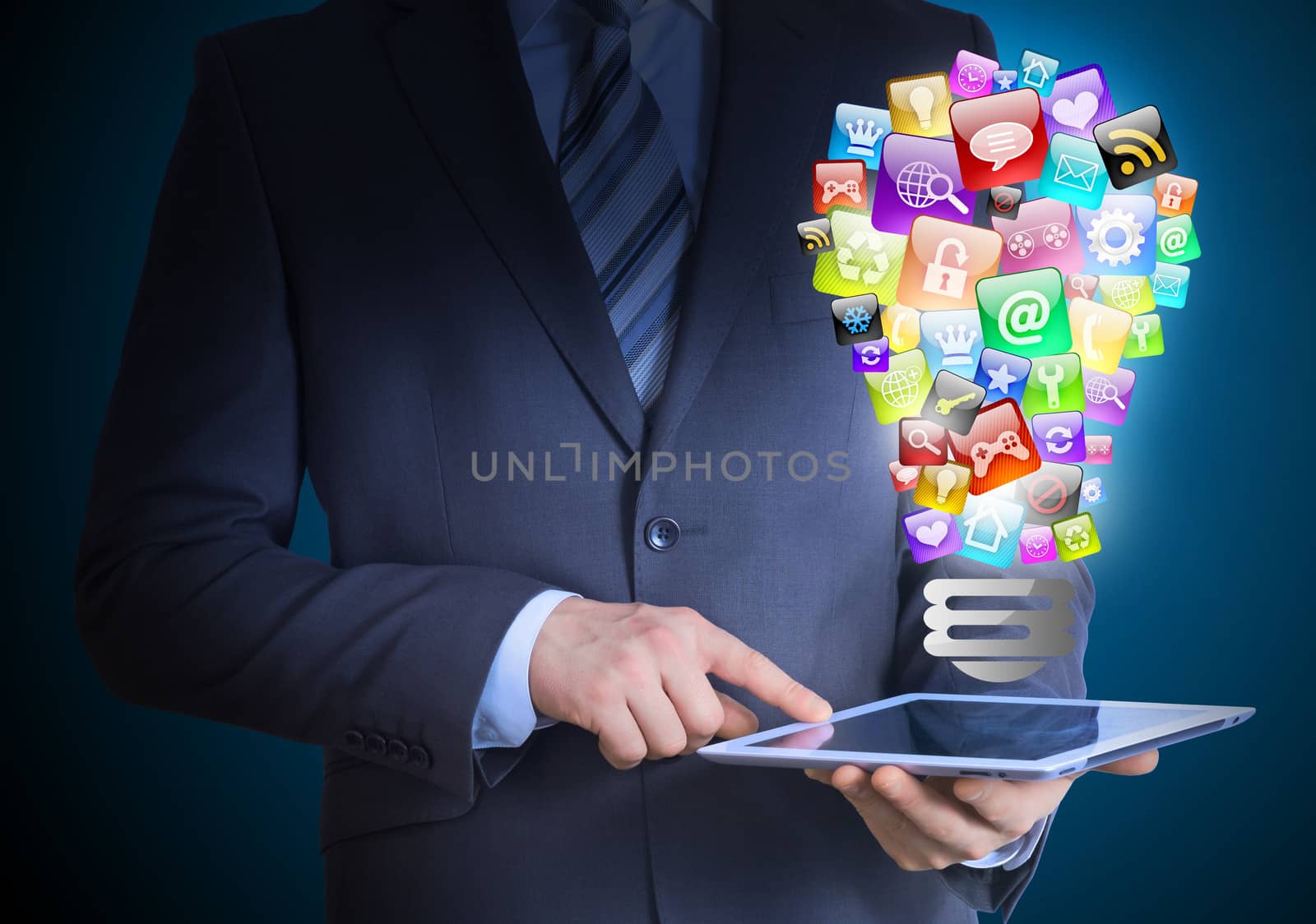 Businessman in a suit holding a tablet in his hands. Above the screen tablet application icons in the form of light bulb