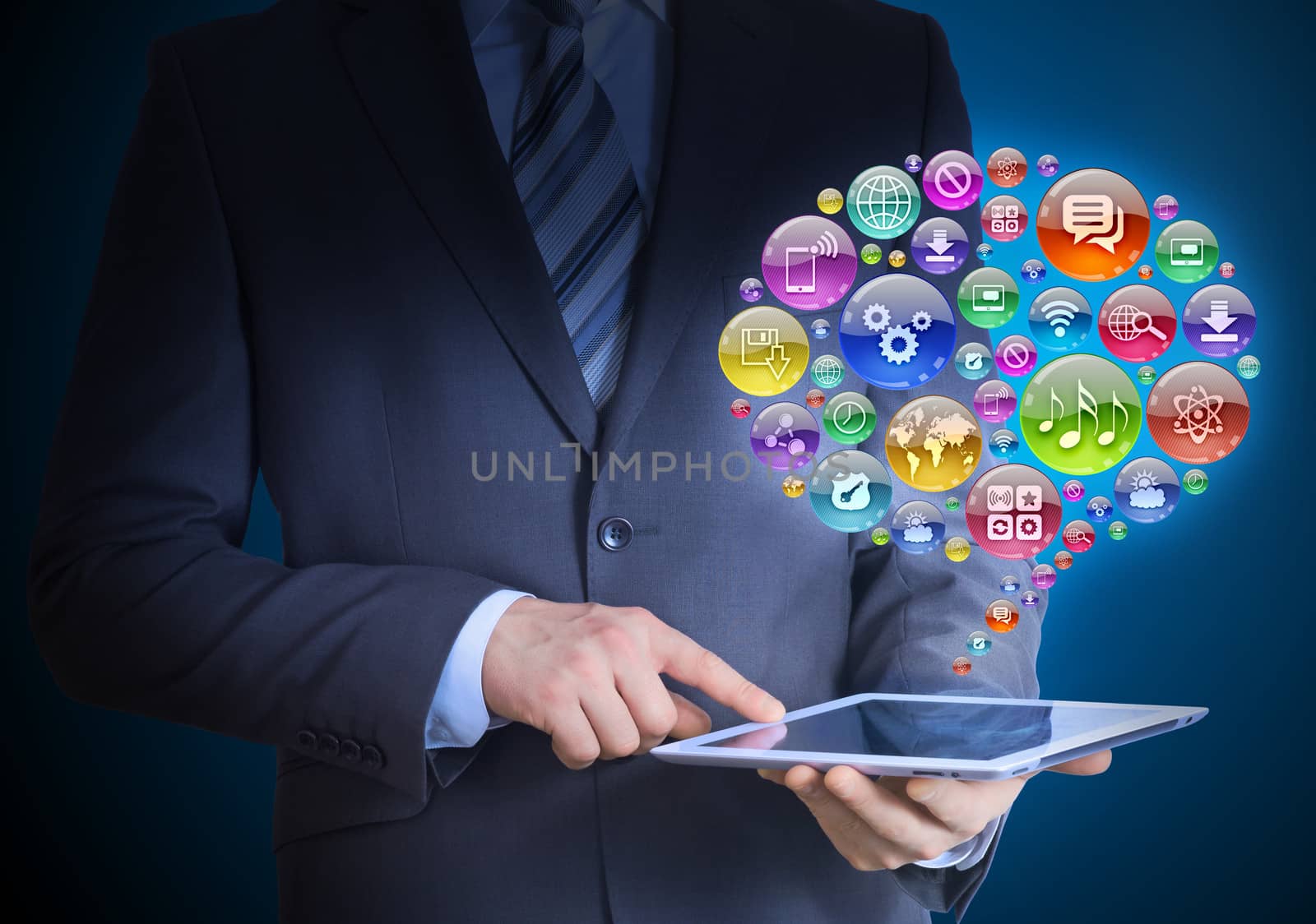 Businessman in a suit holding a tablet in his hands. Above the screen tablet application icons in the form of cloud