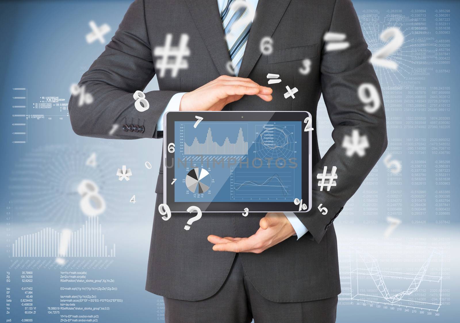 Businessman in a suit holding a tablet computer. Graphs and figures on background