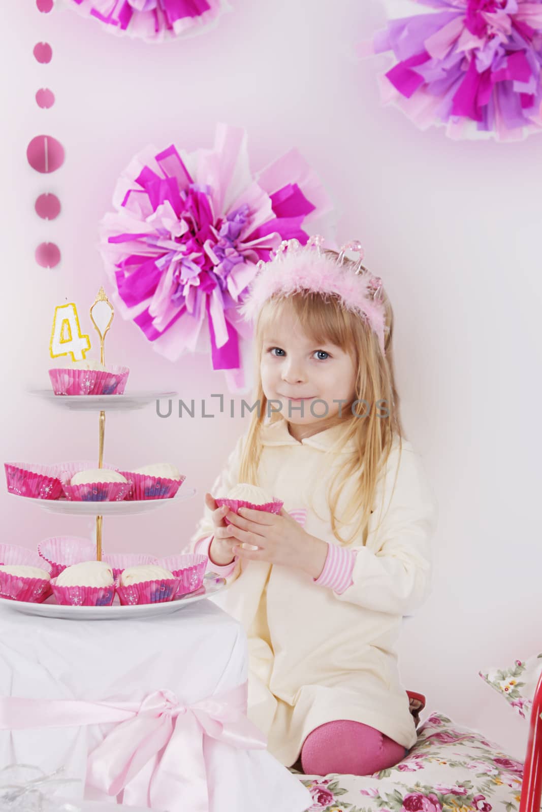 Little girl with piece of cake at pink decoration birthday party
