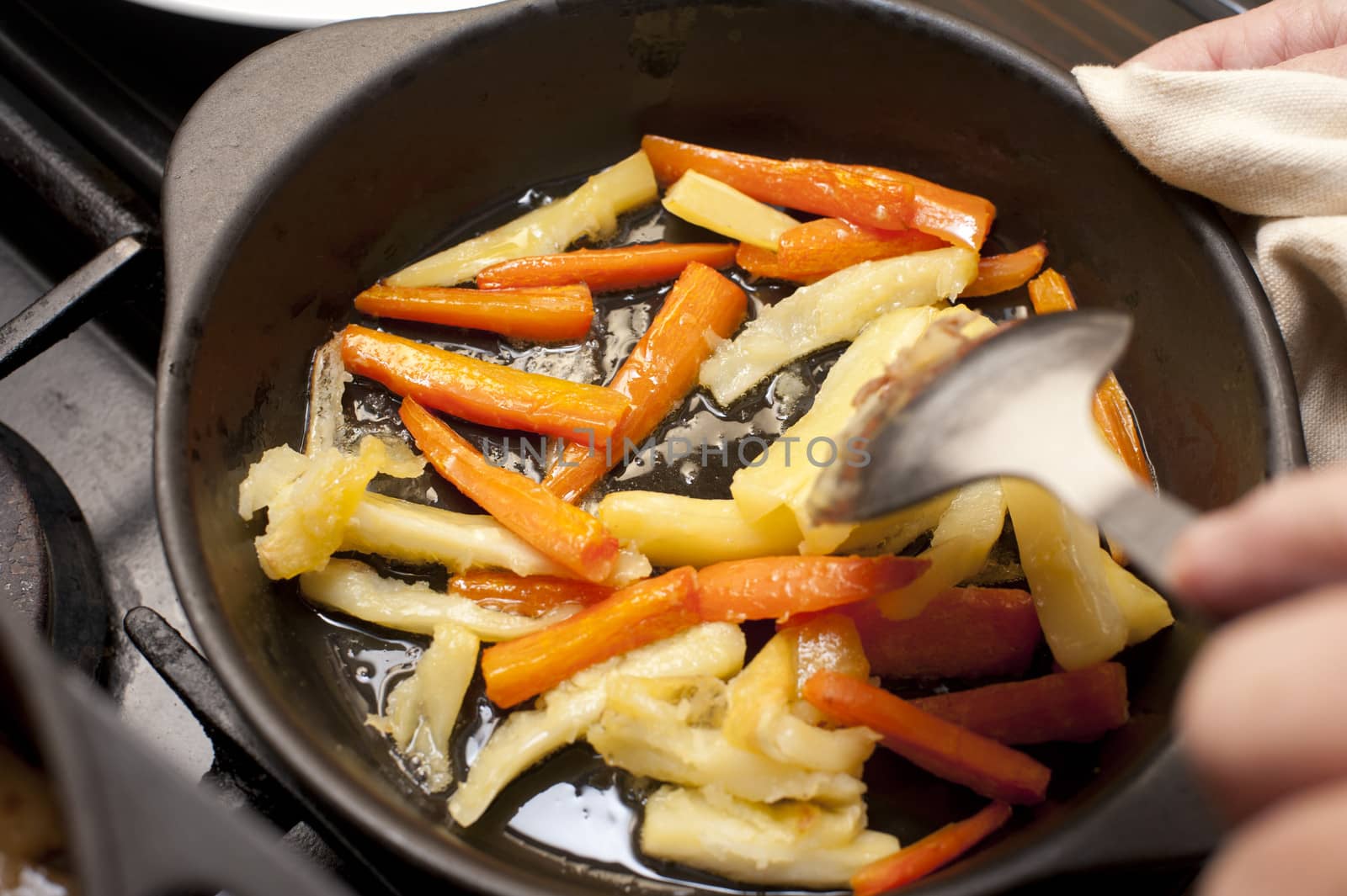 Carrot and parsnip batons being sauteed by stockarch