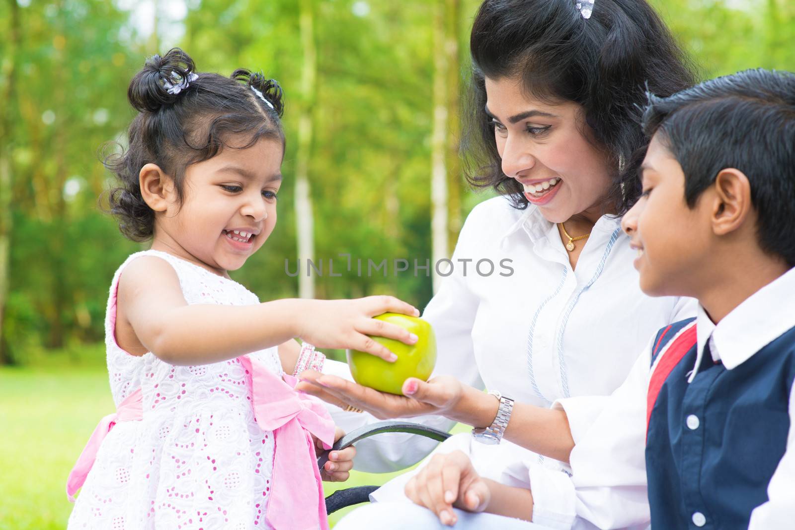 Indian girl sharing apple with family by szefei