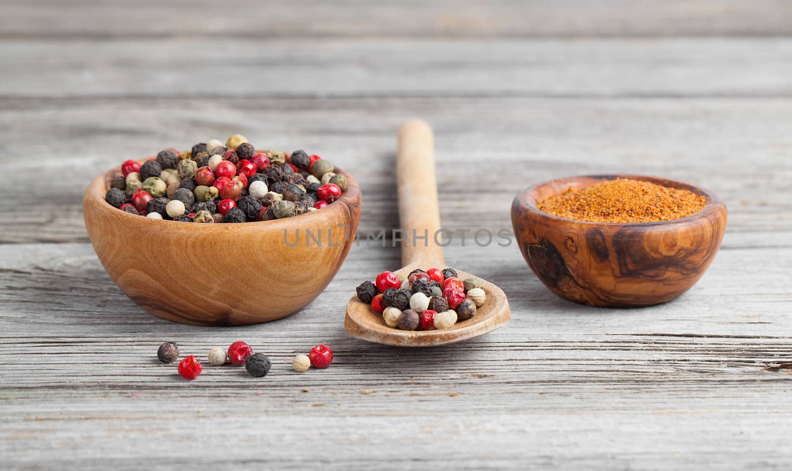 Colored Pepper in the wooden bowl, on wooden board