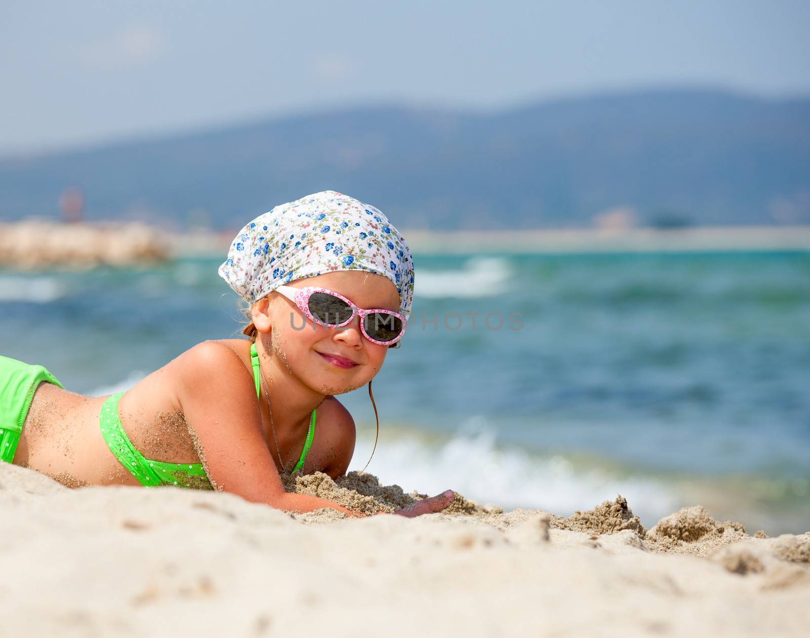 Little girl enjoying summer day on a beach
