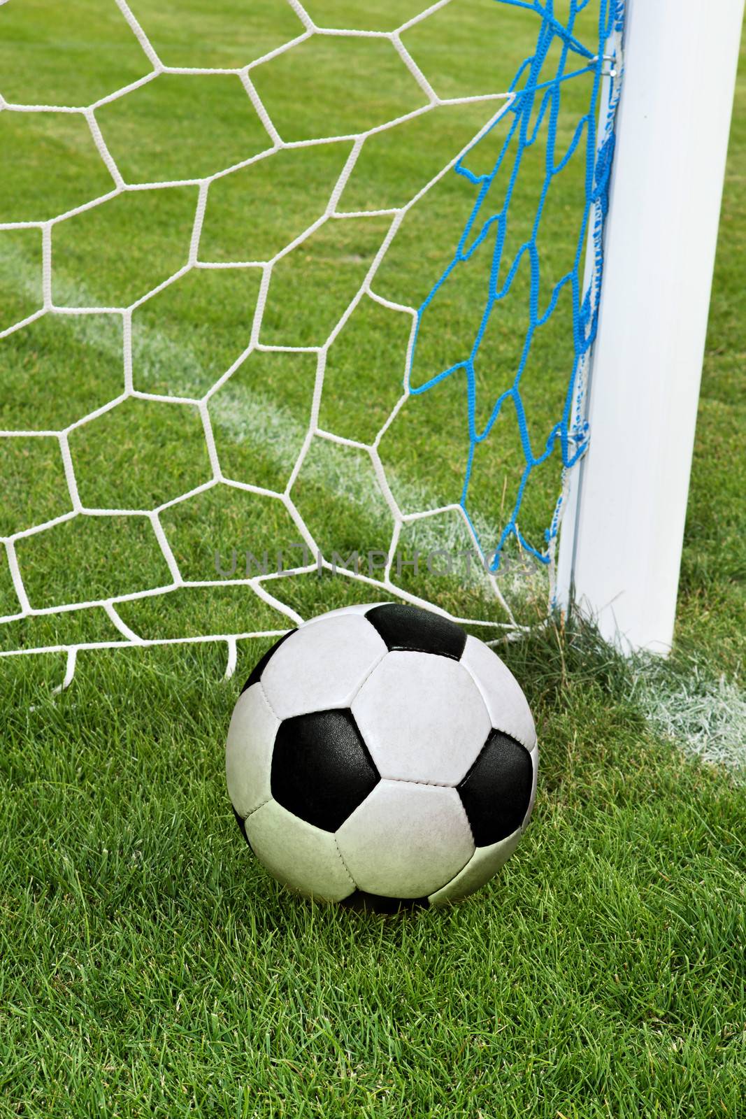 soccer ball in goal net by ssuaphoto