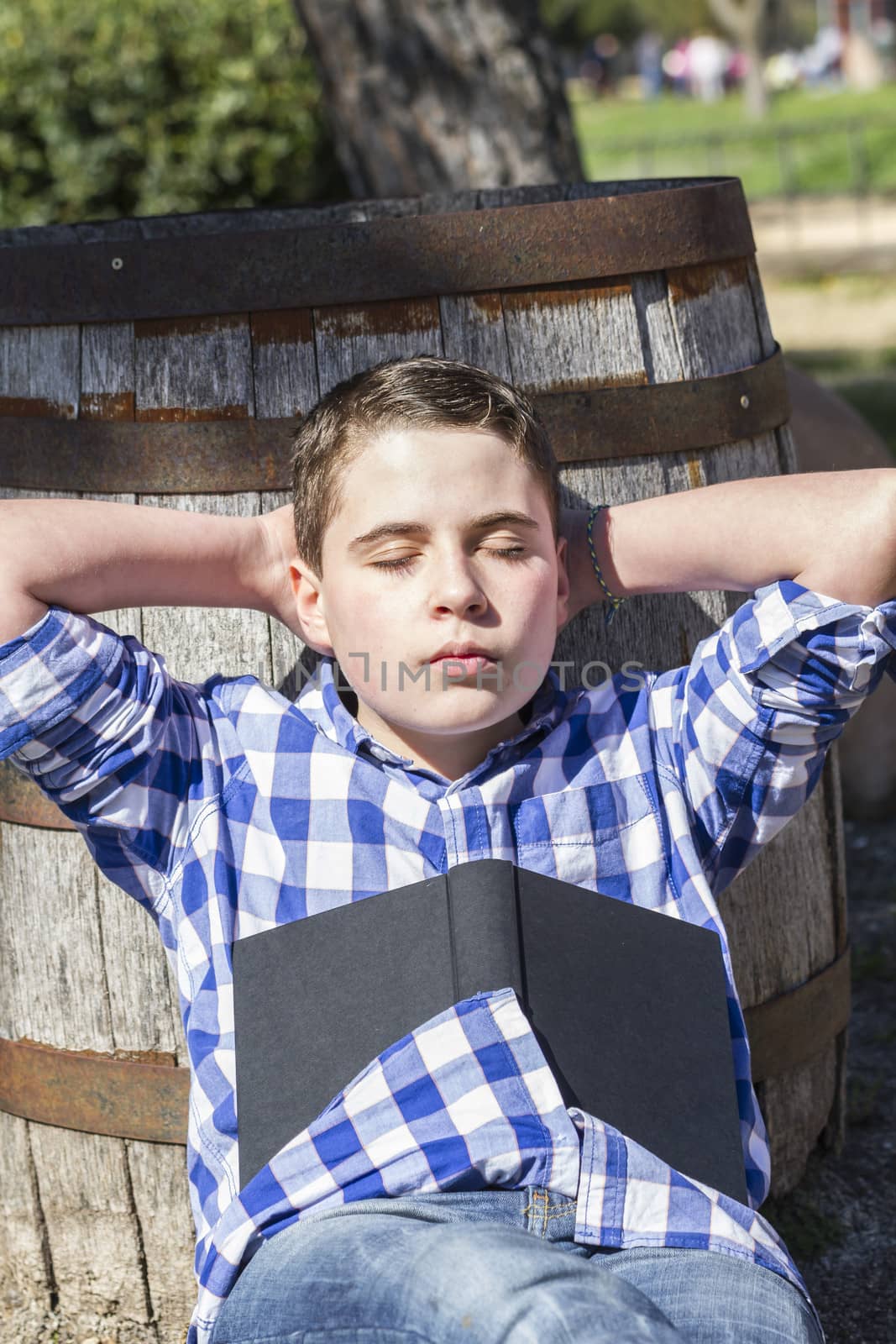 Young boy reading a book in the woods with shallow depth of field and copy space