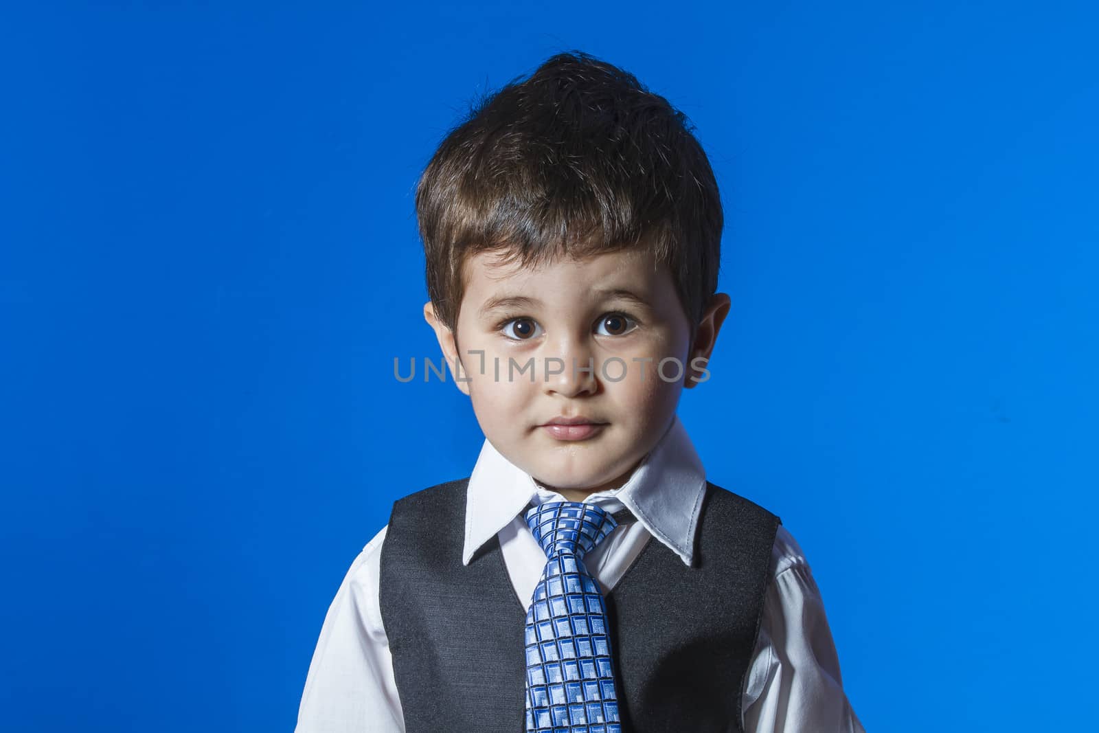 Leader, cute little boy portrait over blue chroma background