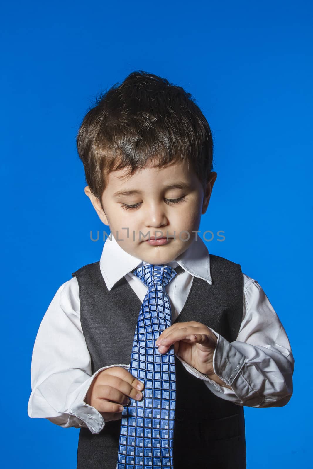 Leader, cute little boy portrait over blue chroma background