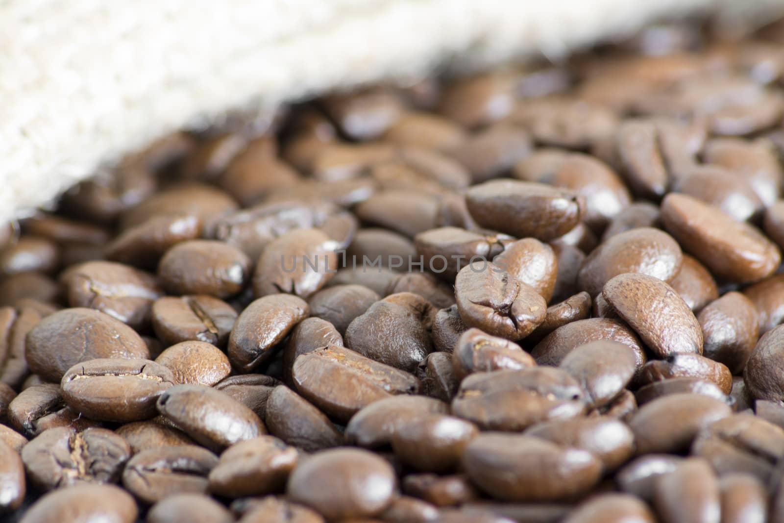 Detail of coffee beans and jute bag at background