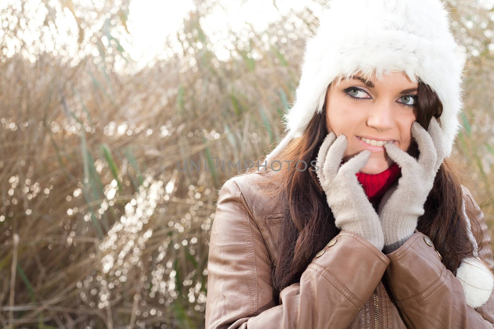 Happy brunette is having a nice time in the park while it's autumn