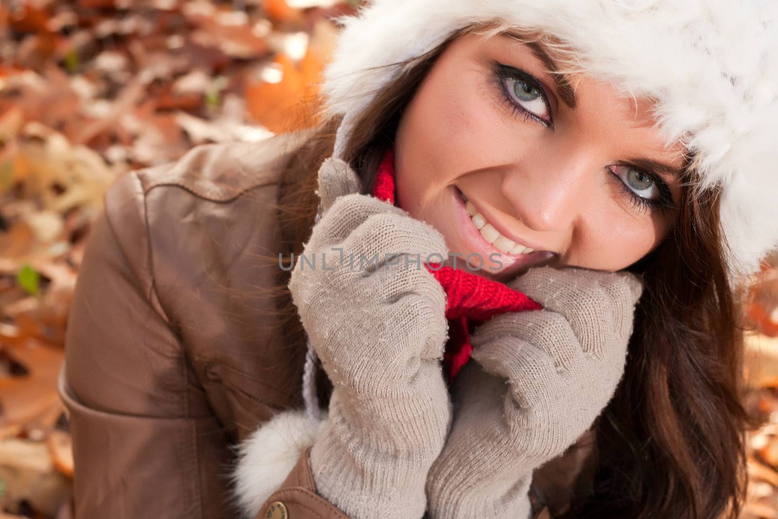 Happy brunette is having a nice time in the park while it's autumn