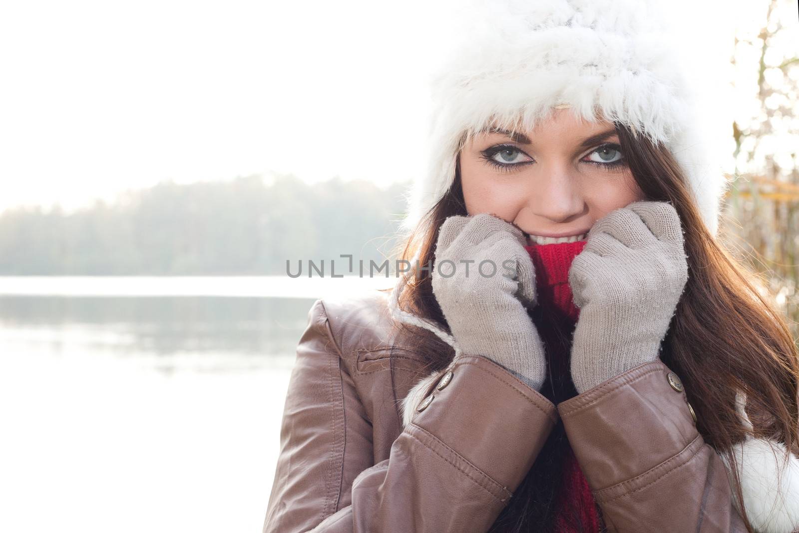 Happy brunette is having a nice time in the park while it's autumn