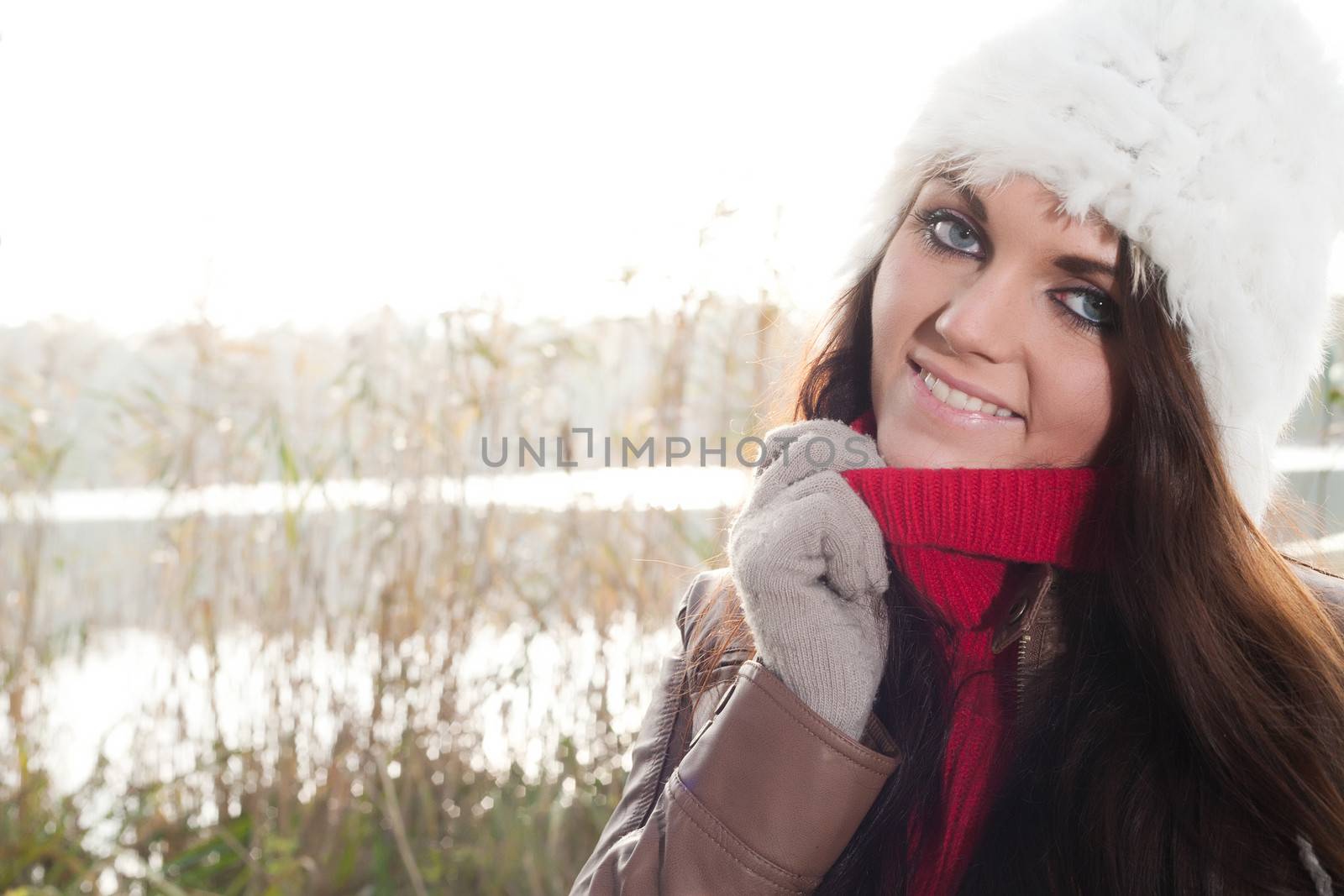 Happy brunette is having a nice time in the park while it's autumn