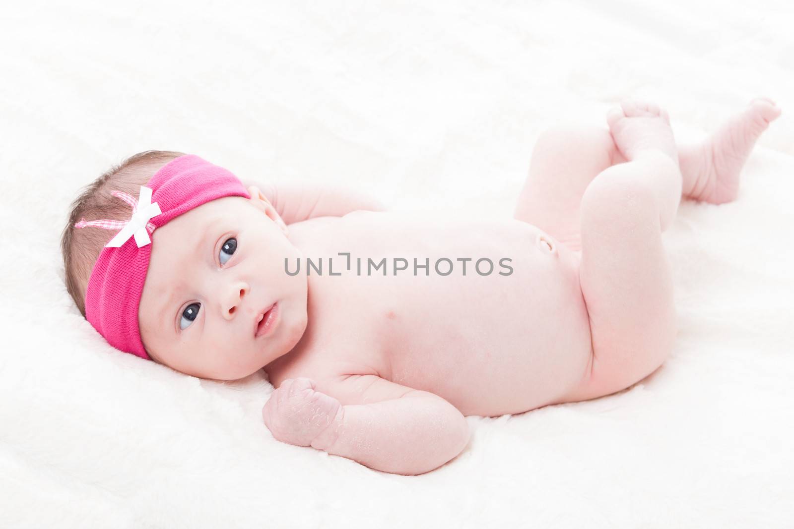 happy newborn baby girl just a week old photographed in the studio