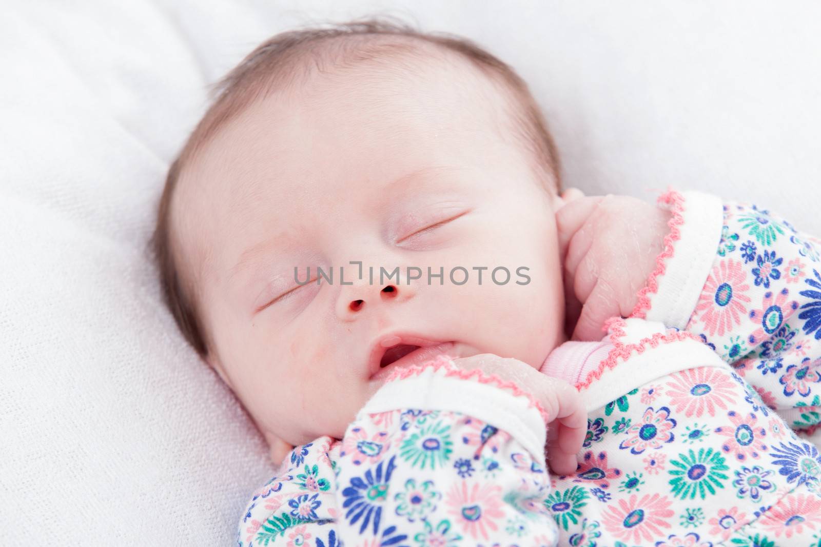 happy newborn baby girl just a week old photographed in the studio