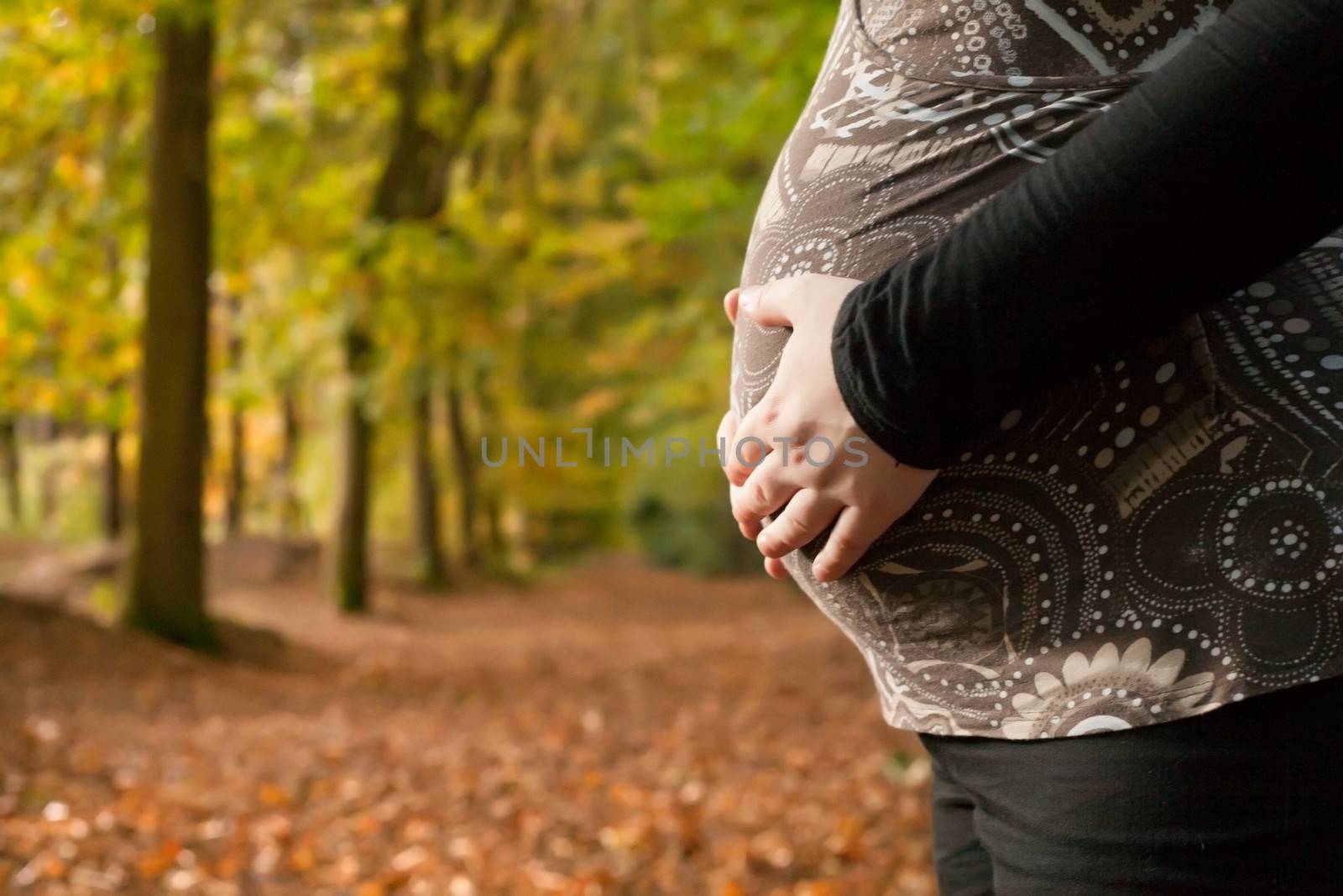 Blond young girl is waiting for her little child. Shoot in the forest