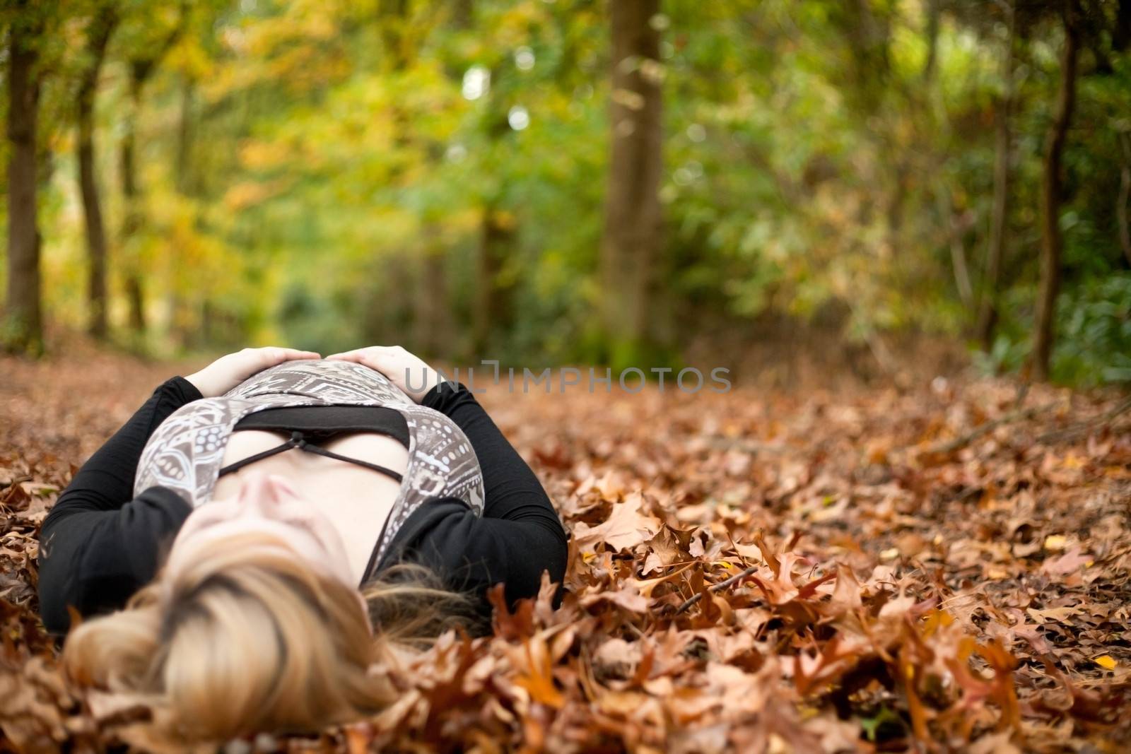 Blond young girl is waiting for her little child. Shoot in the forest