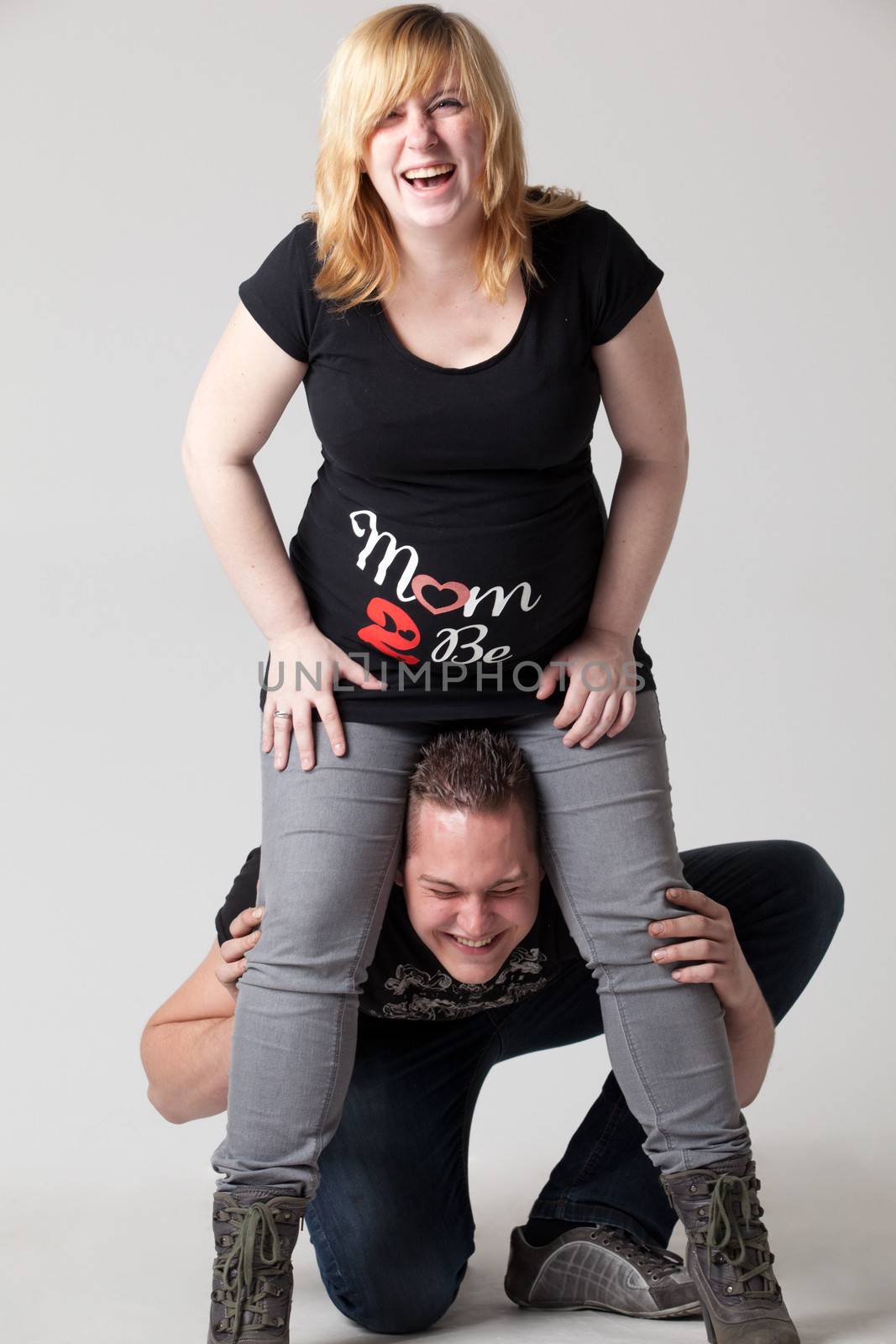 Happy young pregnant couple in the studio