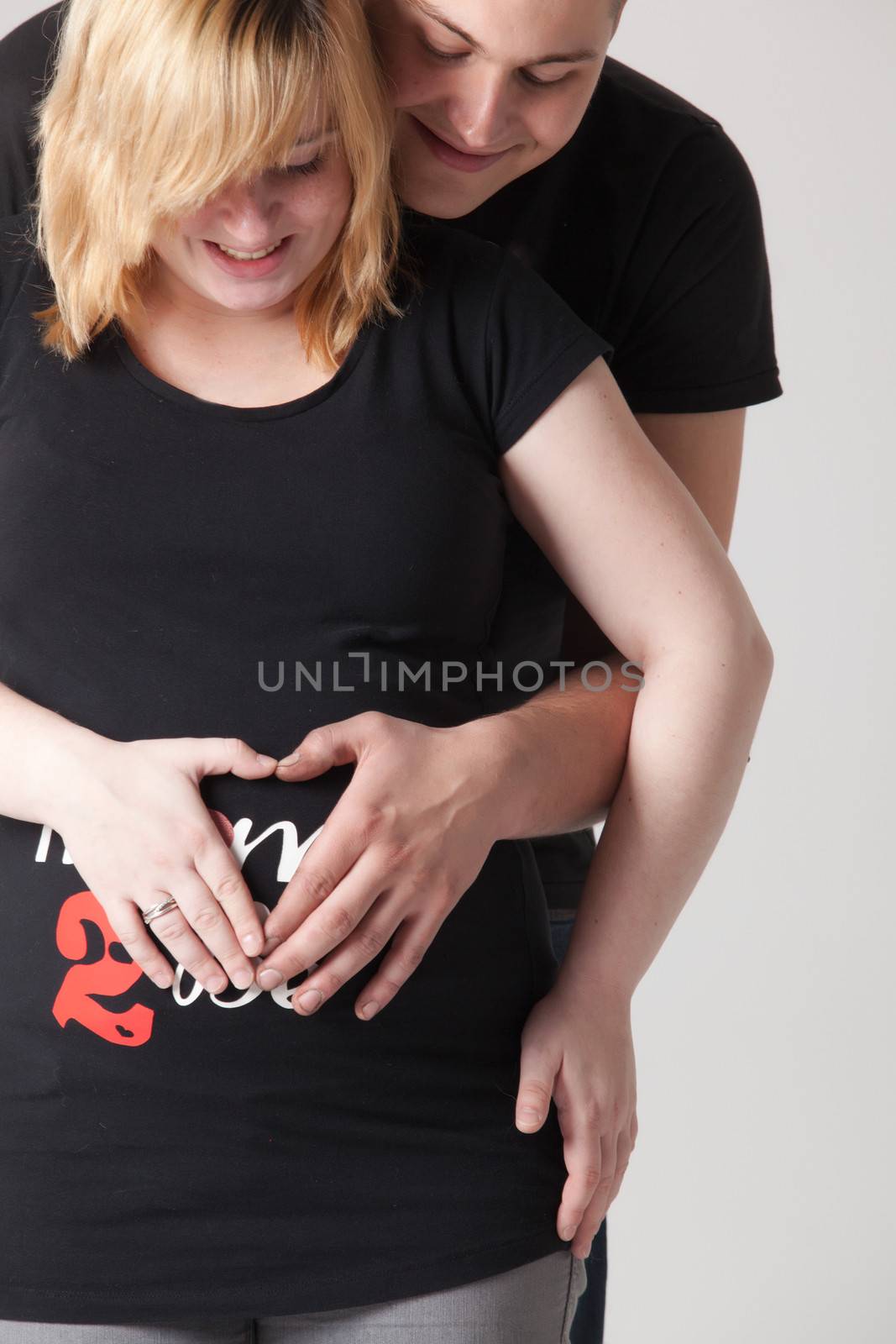 Happy young pregnant couple in the studio
