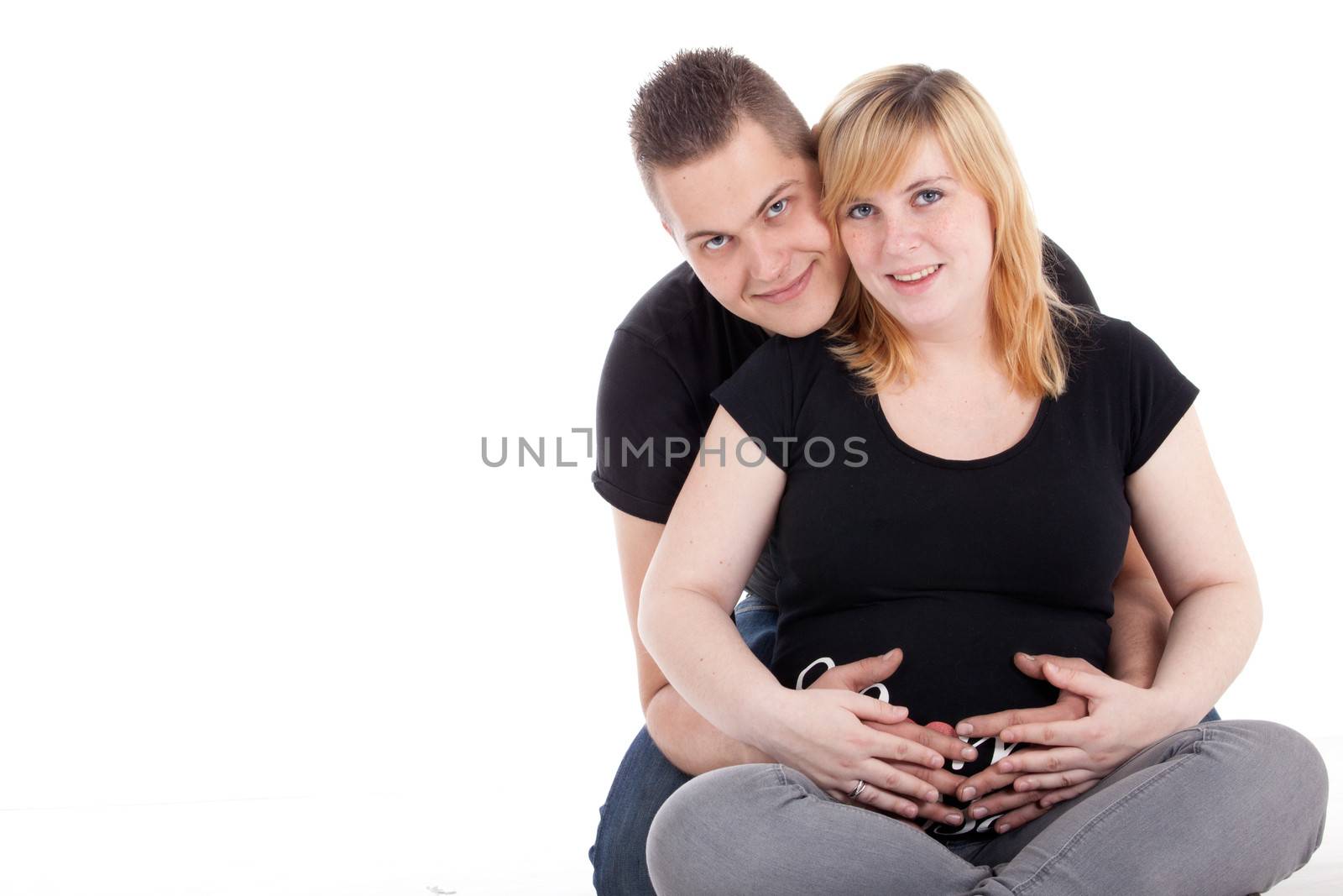 Happy young pregnant couple in the studio