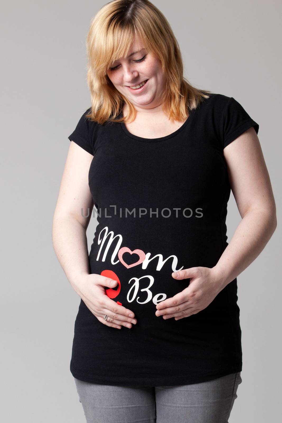 Happy young pregnant woman in the studio