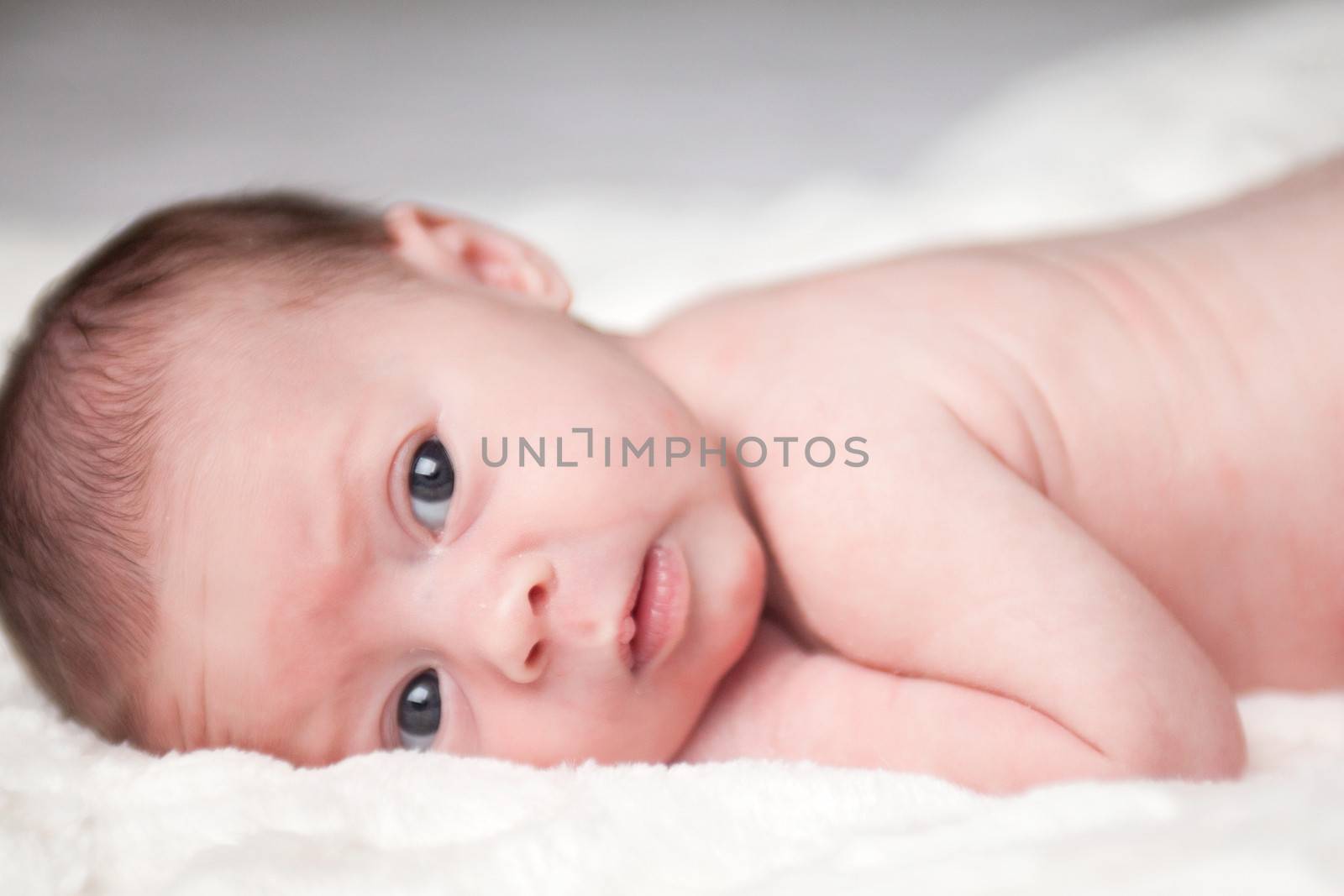 happy newborn baby girl just a week old photographed in the studio