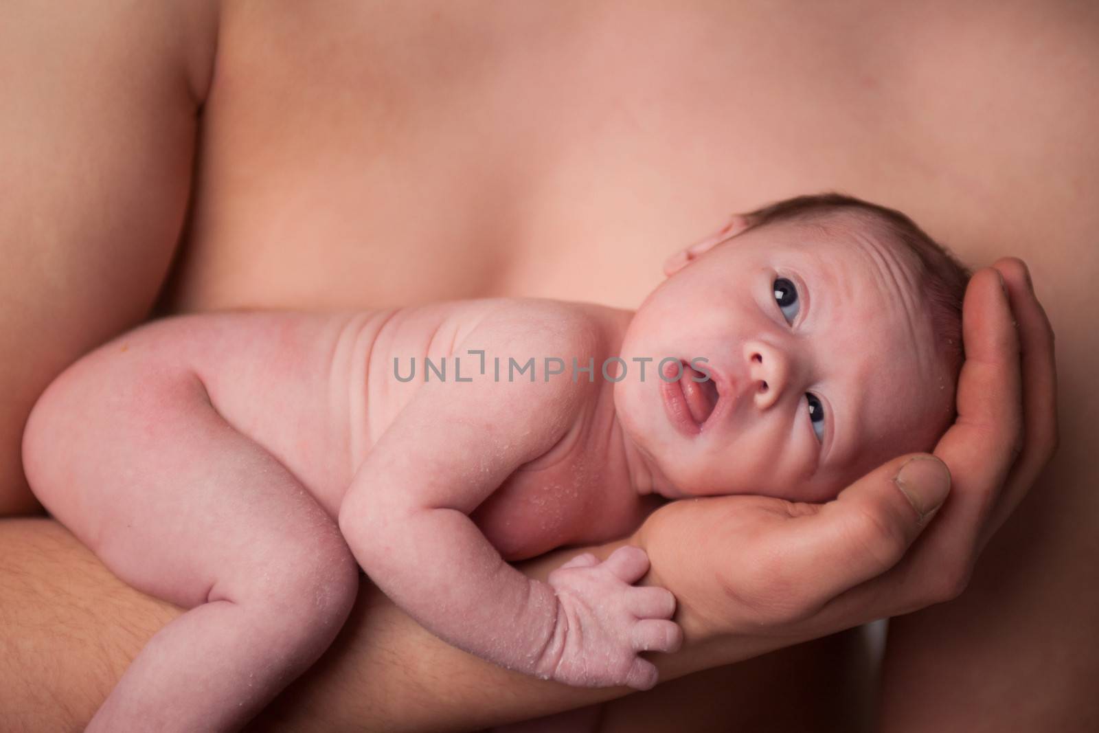 happy newborn baby girl just a week old photographed in the studio