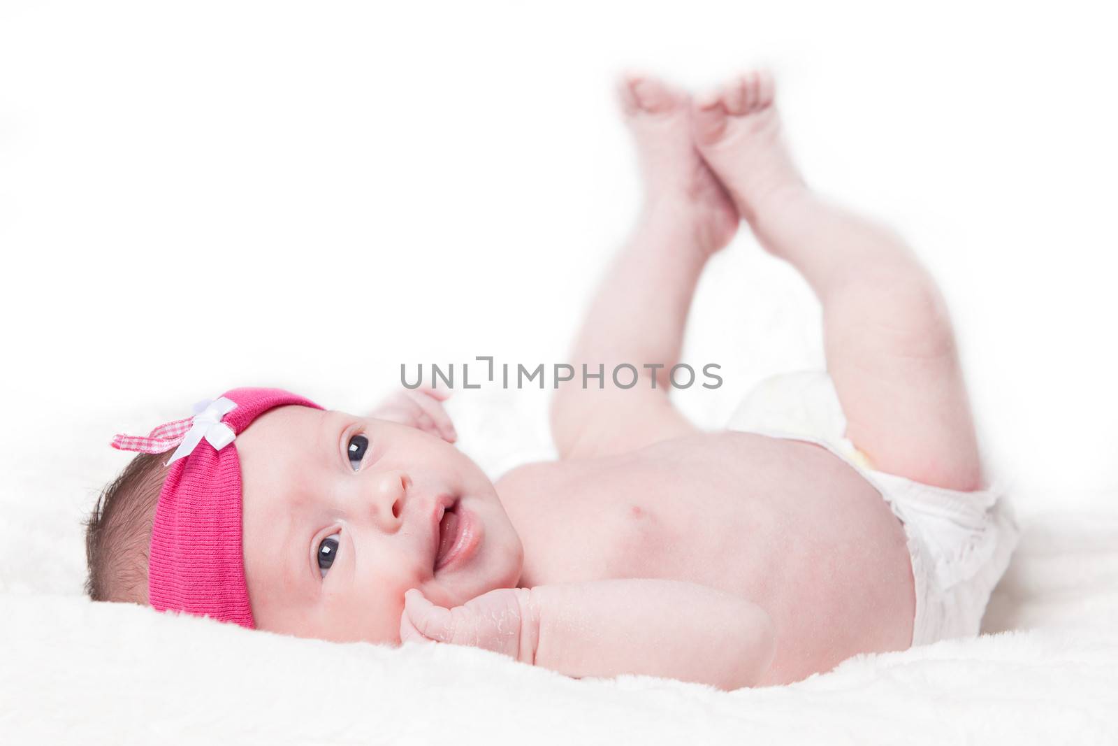 happy newborn baby girl just a week old photographed in the studio