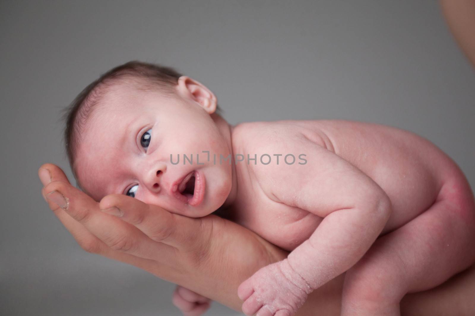 happy newborn baby girl just a week old photographed in the studio