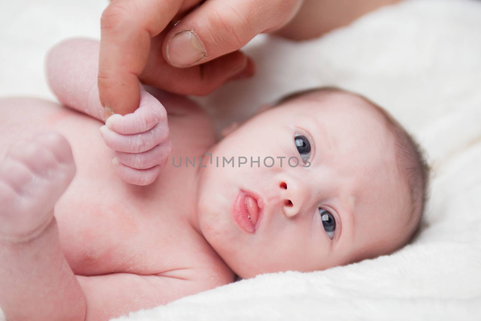 happy newborn baby girl just a week old photographed in the studio