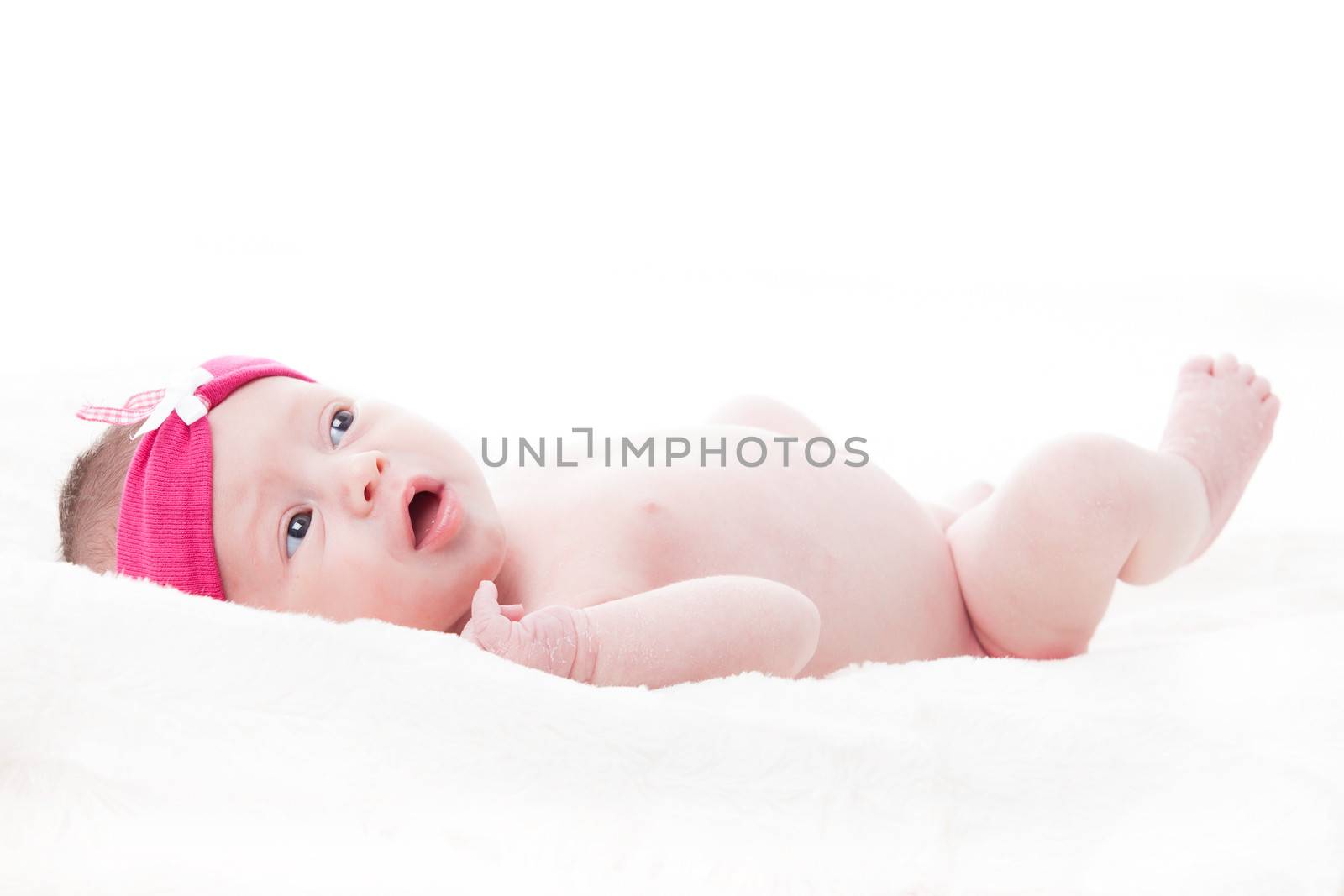 happy newborn baby girl just a week old photographed in the studio