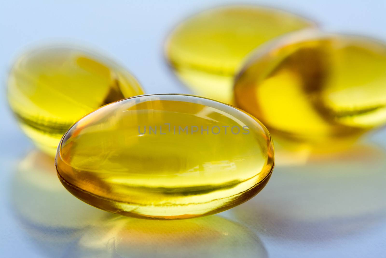 Macro to a yellow pills with a blue background.