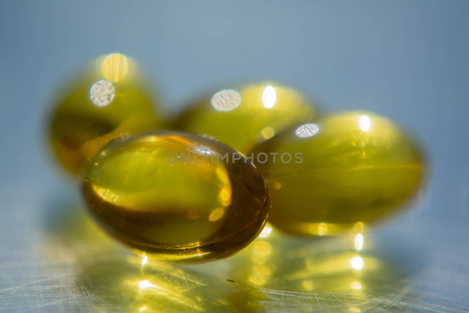 Macro to a yellow pills with a blue background.