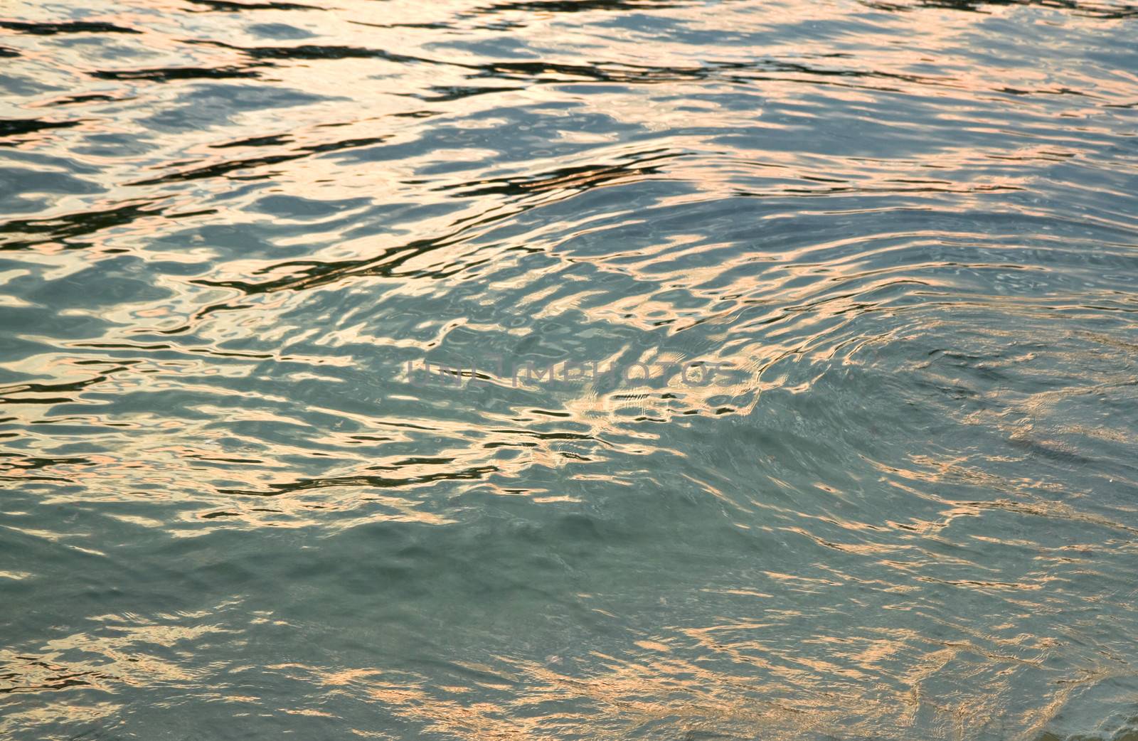 Sunset reflections on water surface by Colette