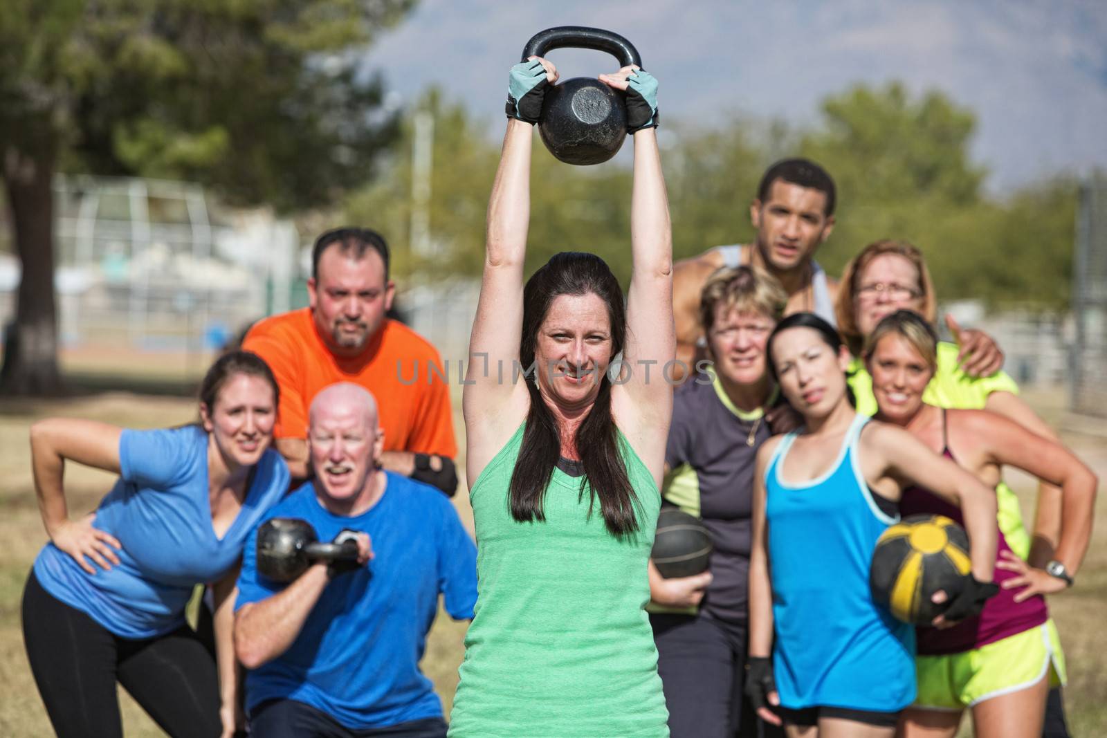 Group of people watching woman lifting kettle bell weights