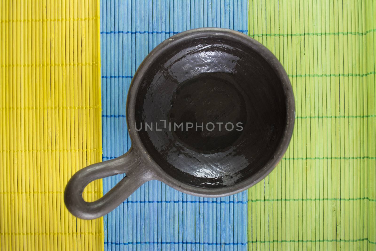 Mexican Oaxaca pottery bowl brown color on tablecloth made of wooden branches.