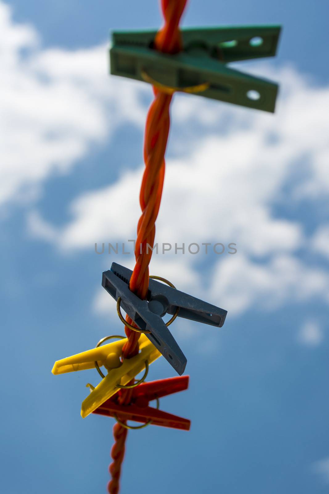 Four plastic pegs against blue and cloudy sky