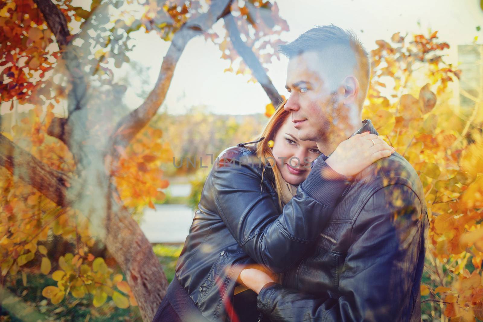 Attractive young couple embracing in a city park on a background of trees
