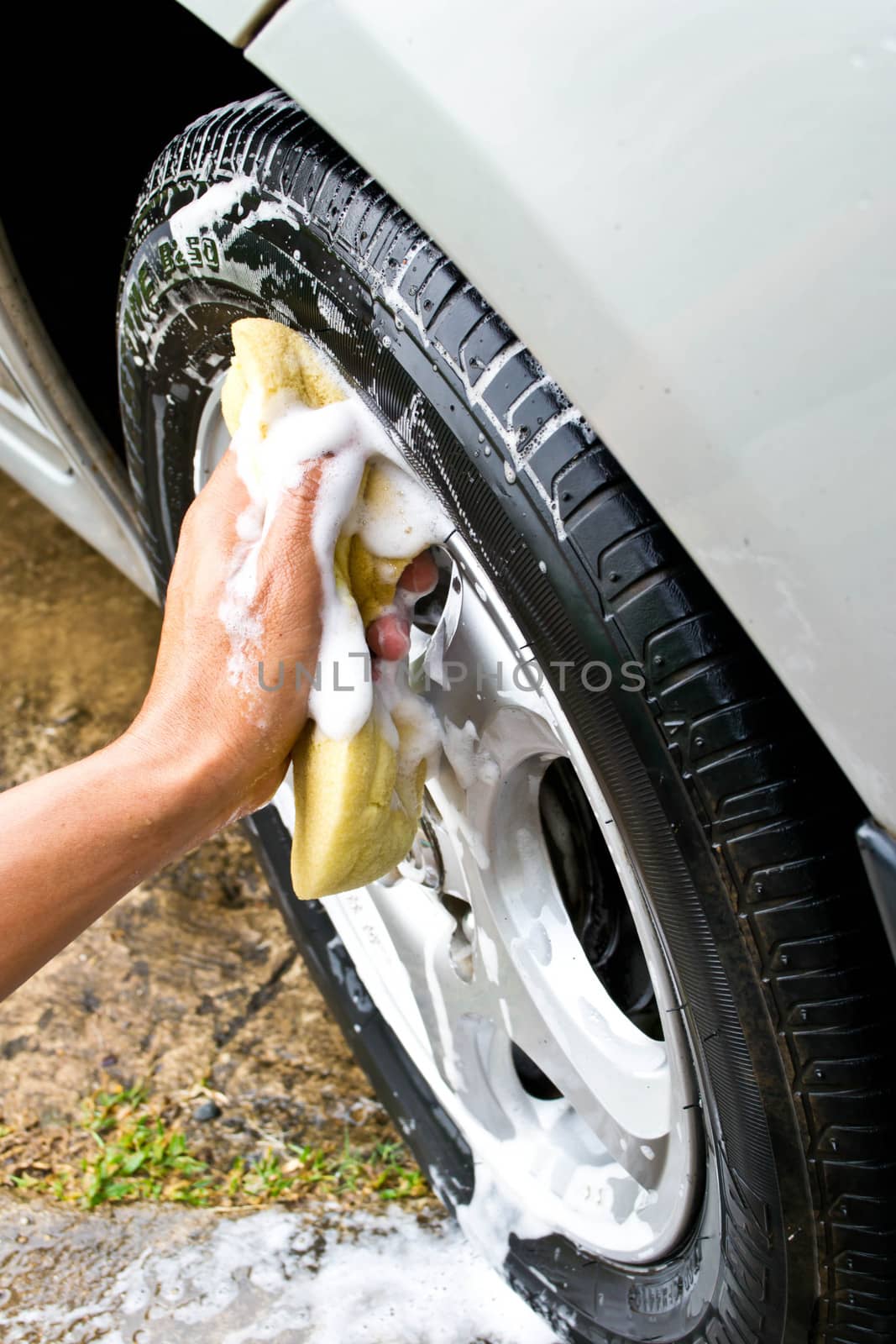 man washing car with a yellow sponge 
