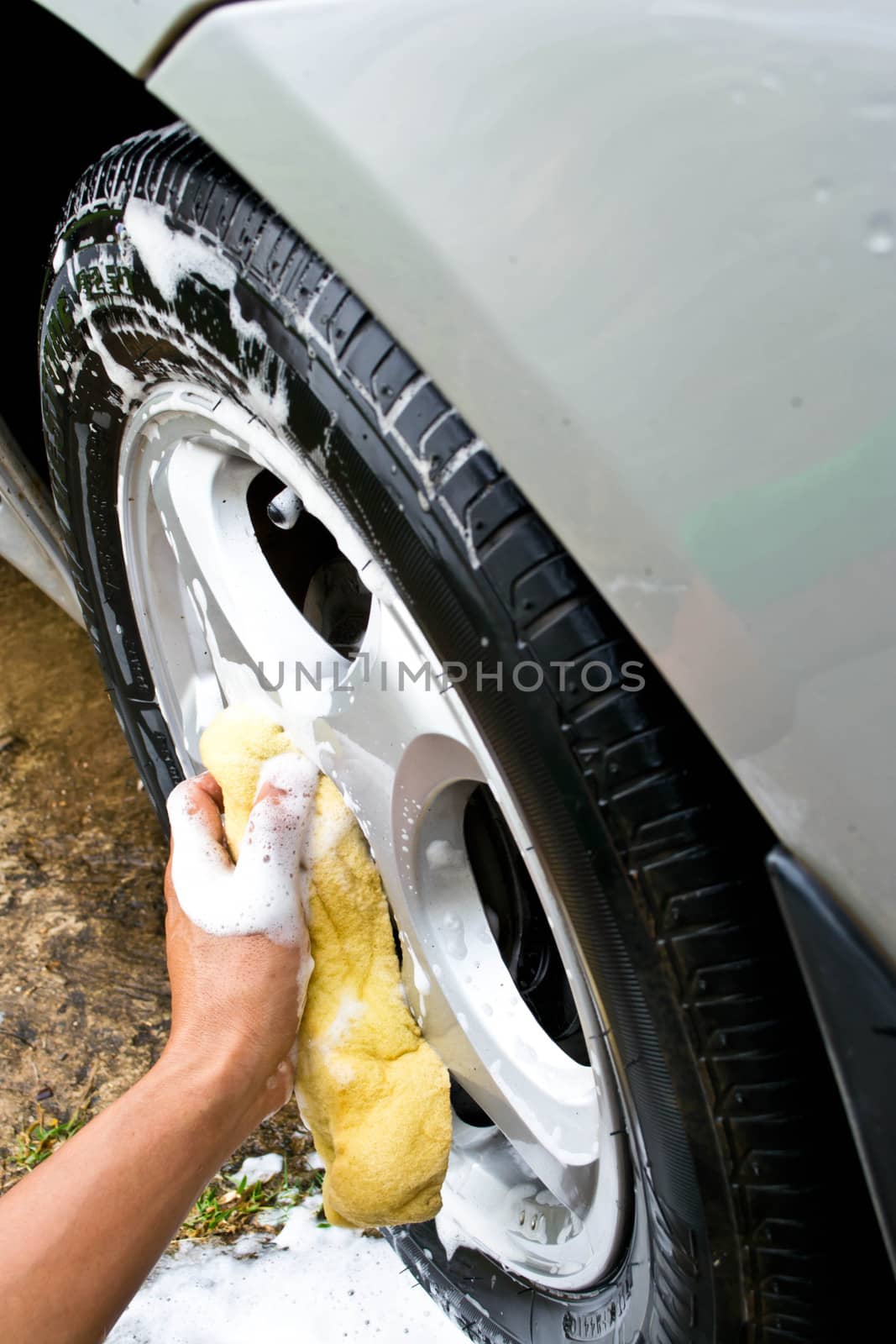 man washing car with a yellow sponge