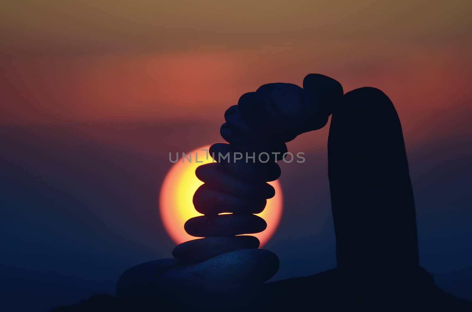 Pile of pebbles balancing on sky background