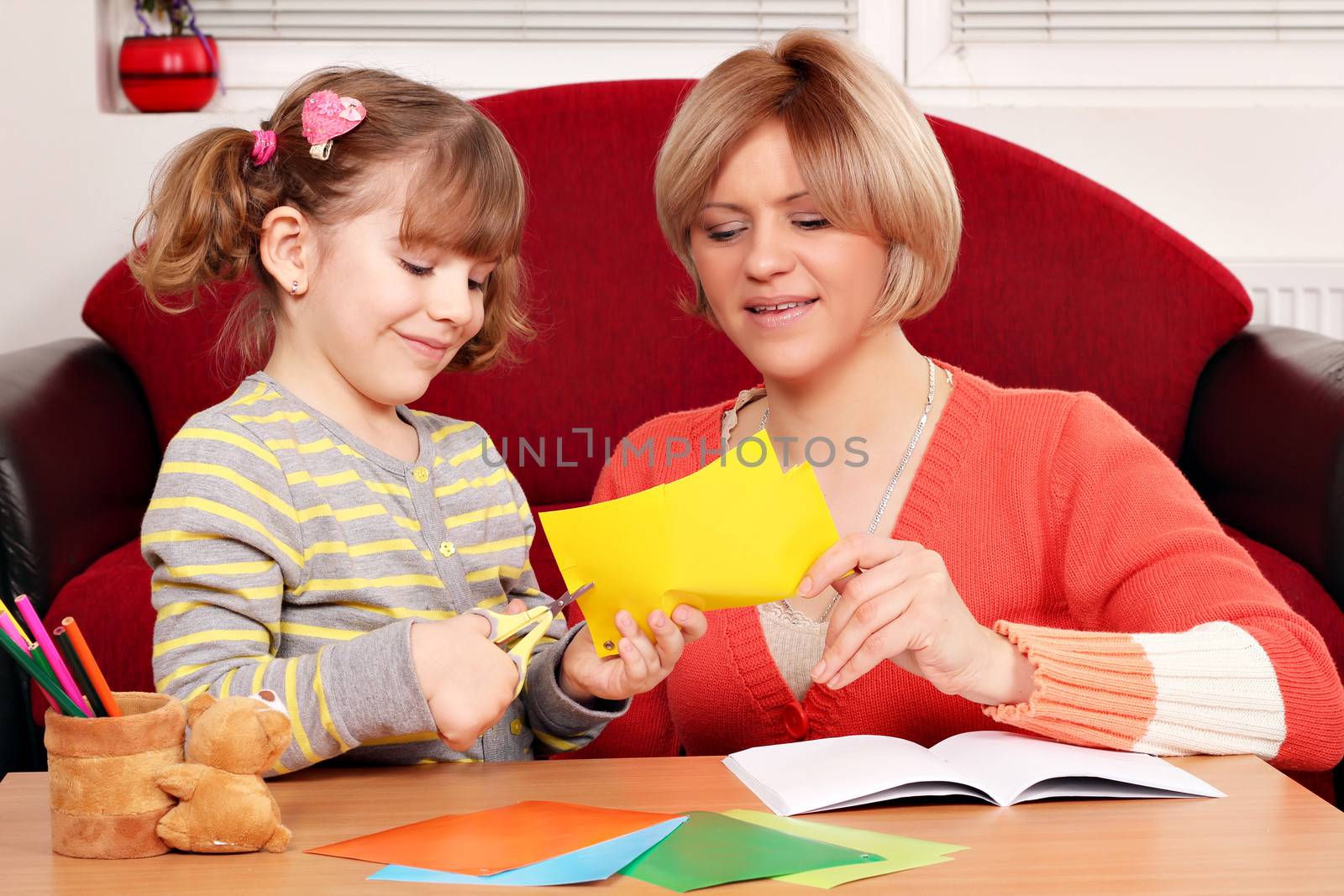 happy mother and daughter cutting paper