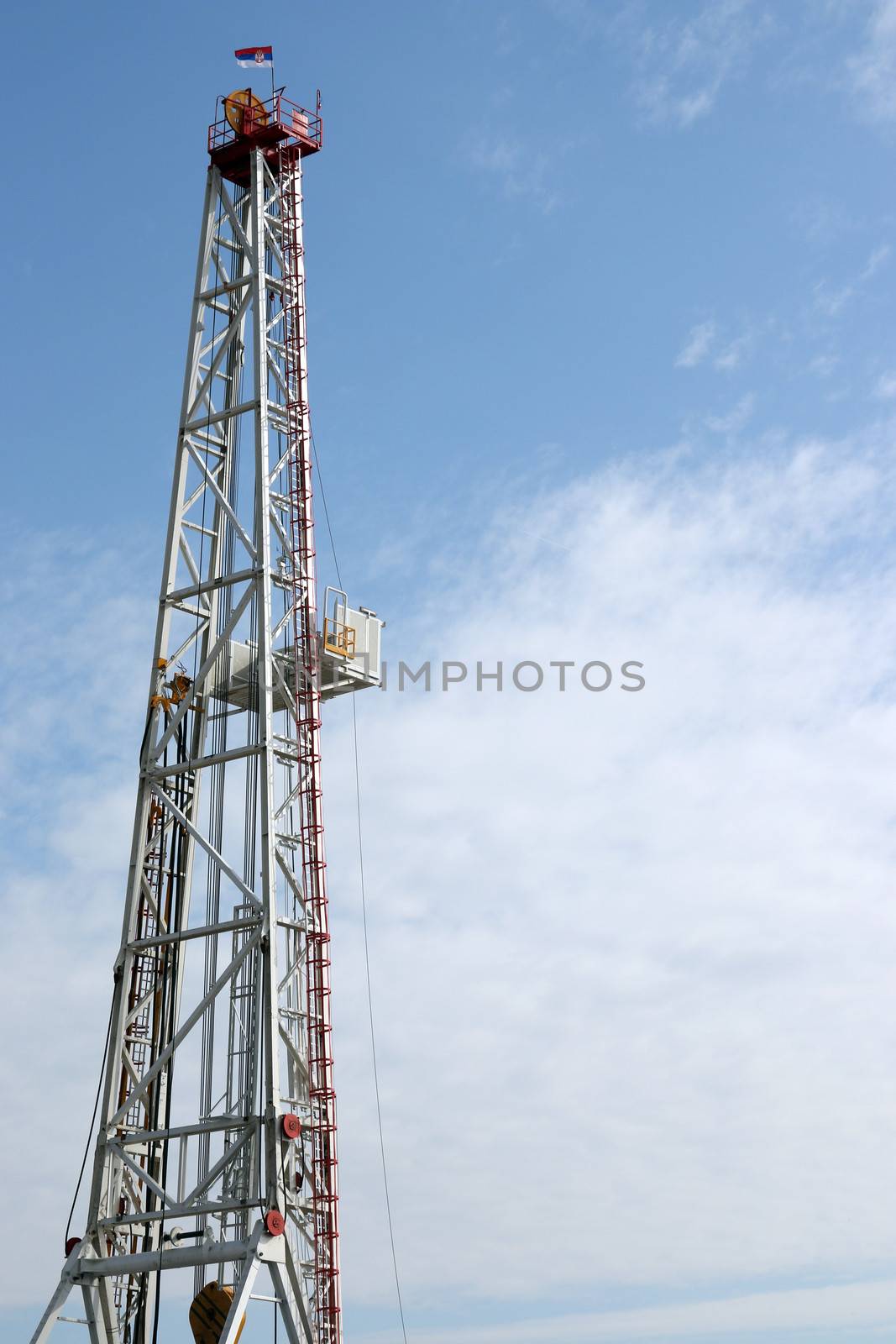 oil drilling rig tower on blue sky by goce