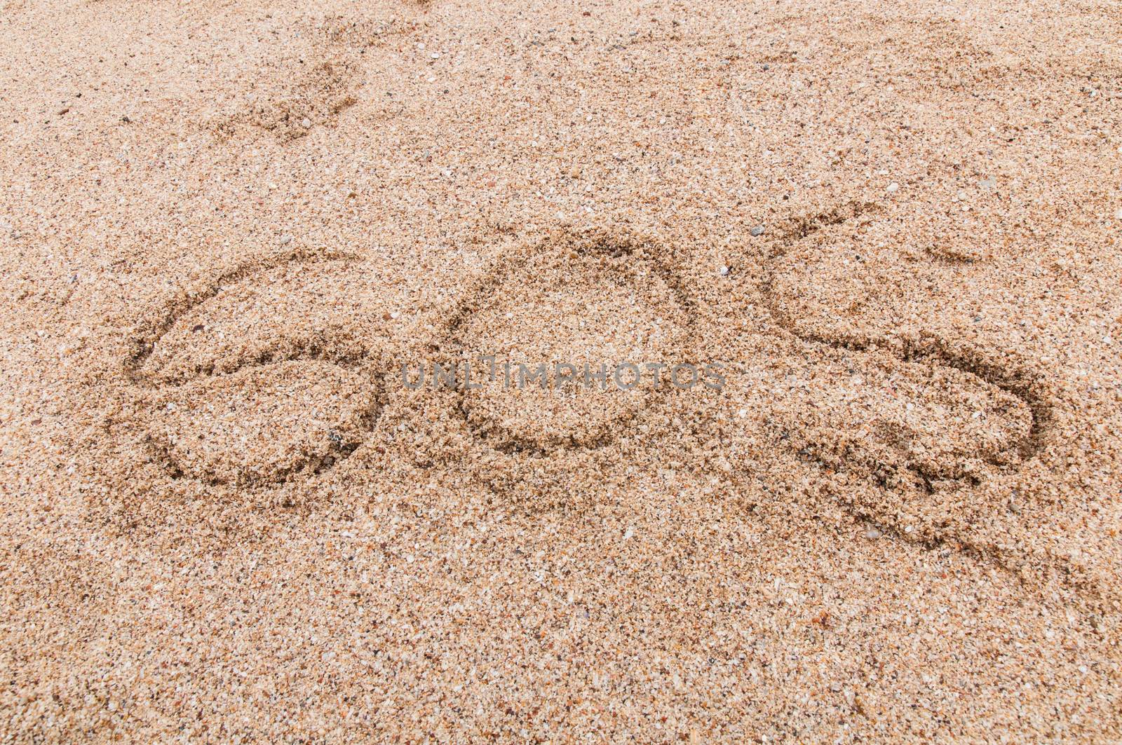 S.O.S written in the sand with a finger or stick