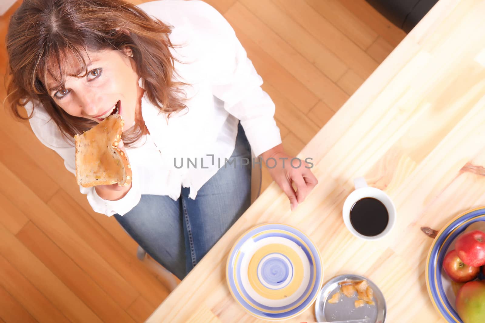 Portrait of a beautiful mature woman sitting in the kitchen. 