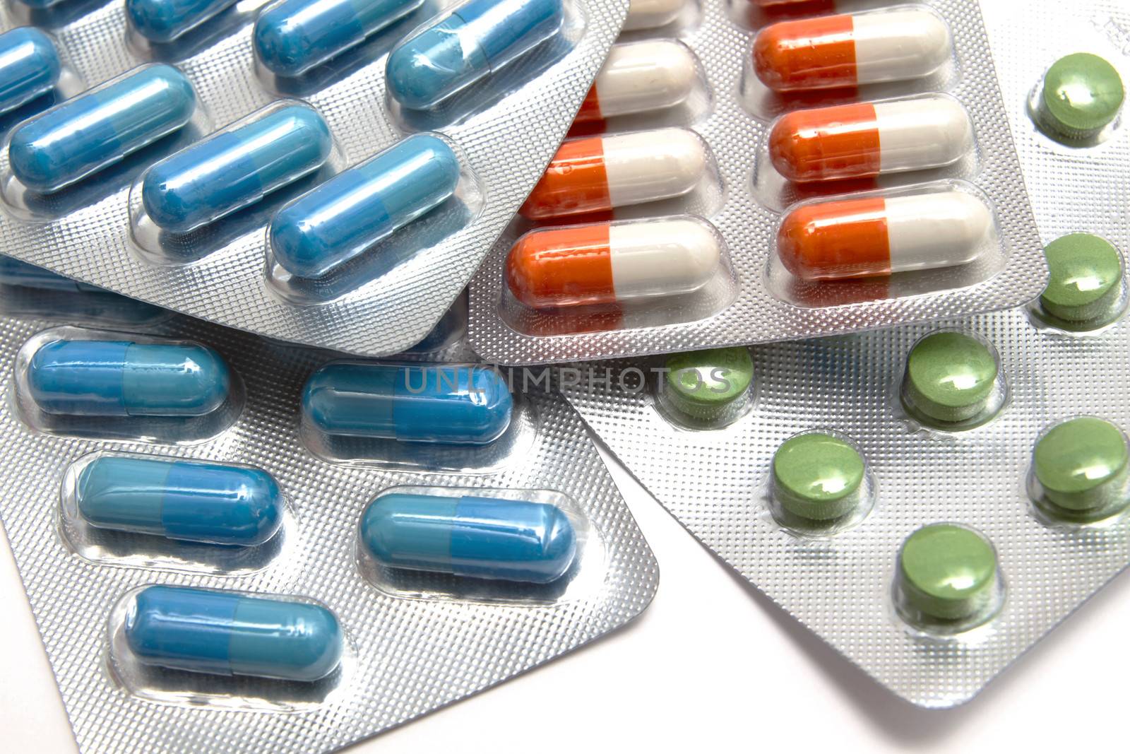  colorful capsules and pills closeup on white