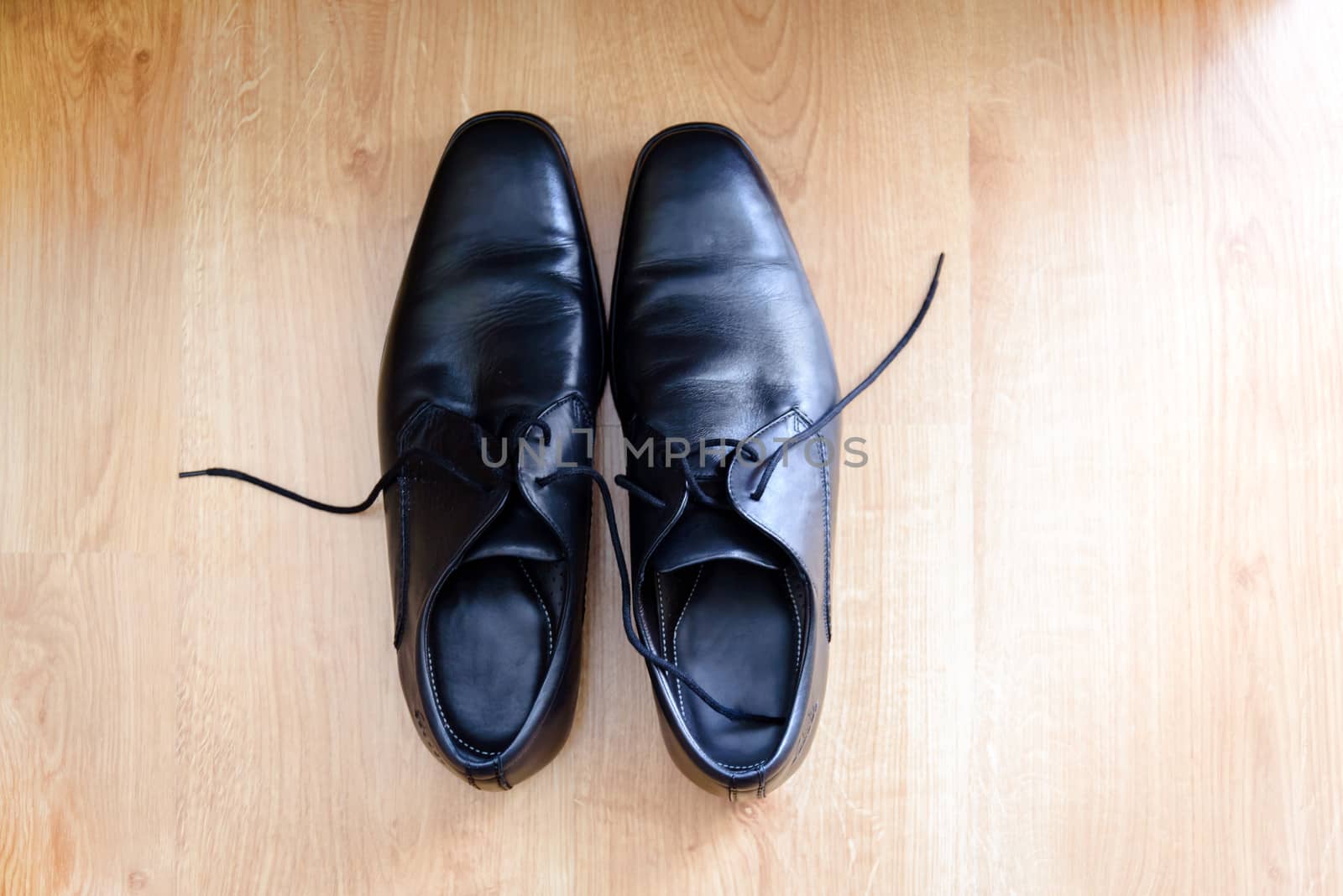 Shot from above, in wooden pattern background, a pair of men's black  elegant shoes for suit.