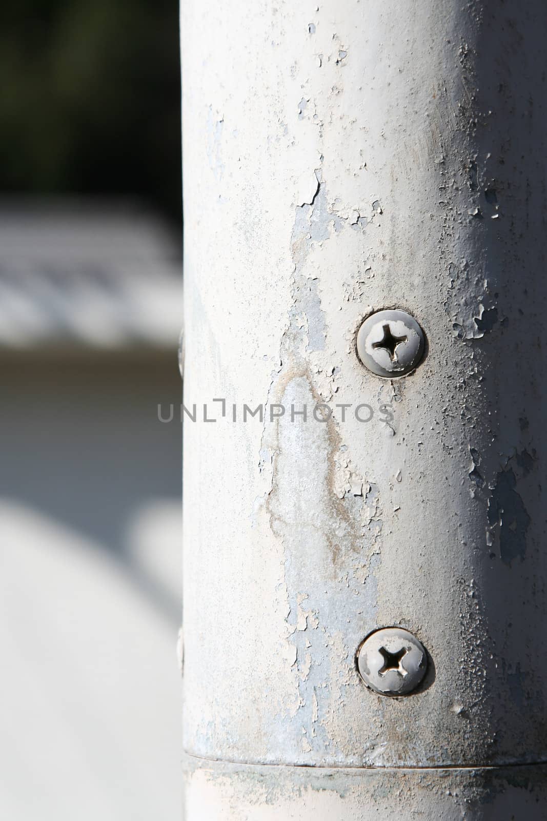 Rusty screw on a white pipe, close up