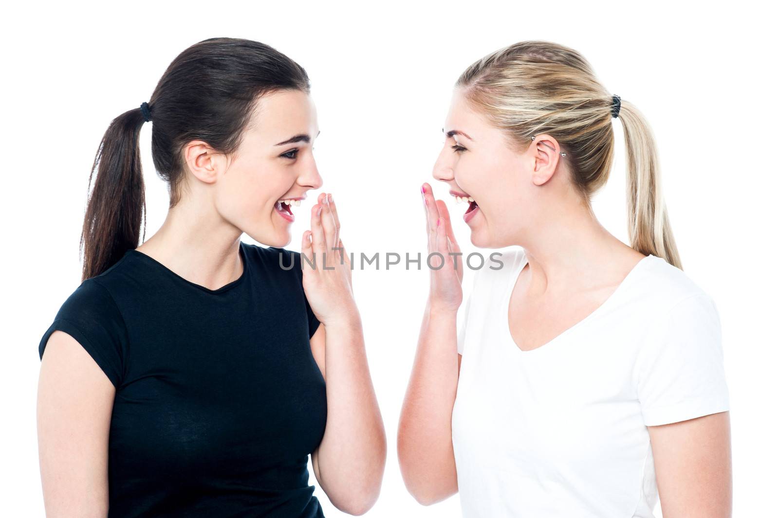 Surprised young girls laughing out loud by stockyimages