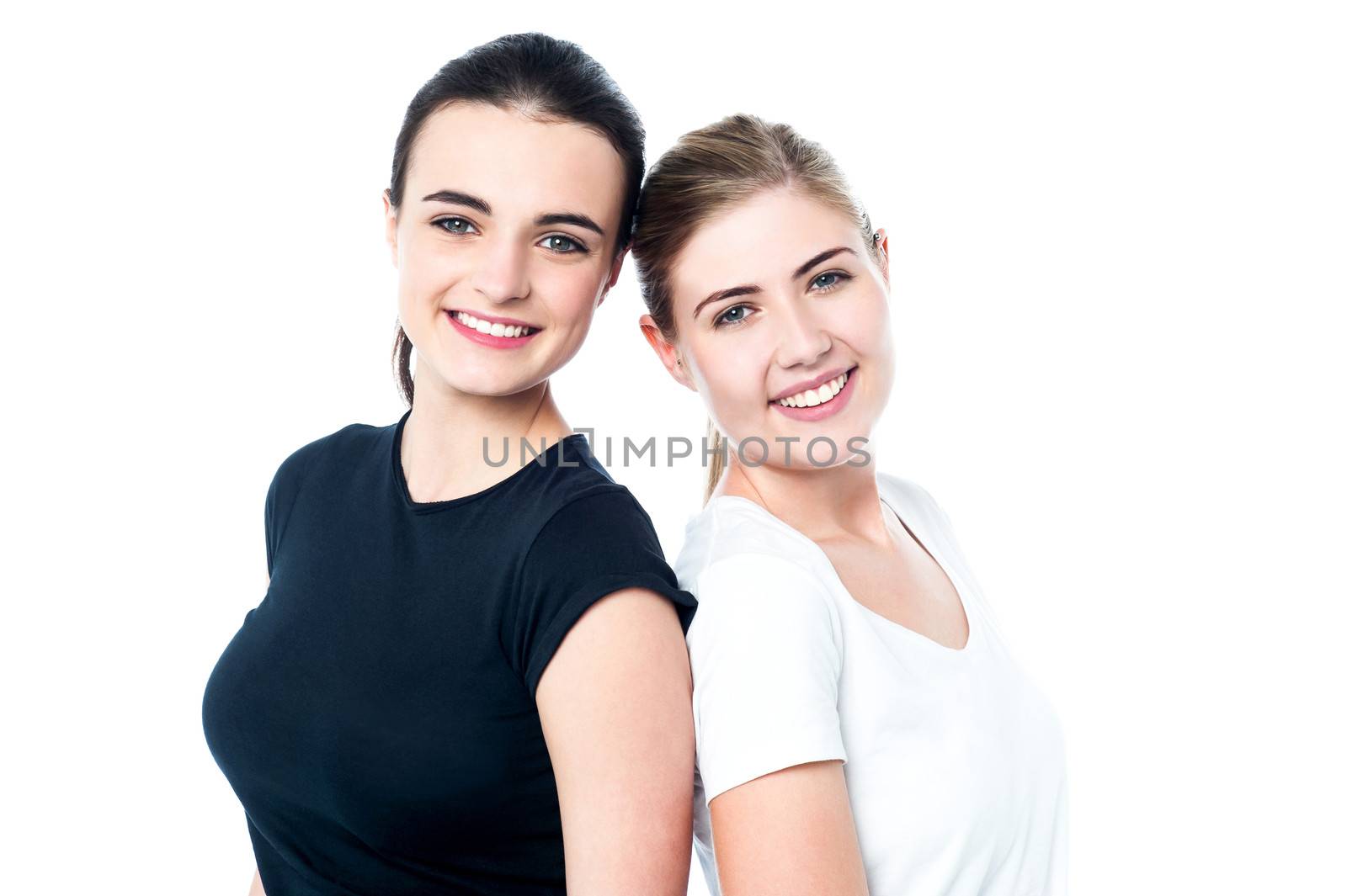 Happy teen girls back to back by stockyimages